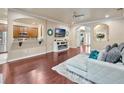 Open-concept living area with hardwood floors, a white sofa, and a view into the kitchen at 6932 Gray Catbird Loop, Wesley Chapel, FL 33545