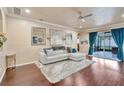 Bright living room featuring hardwood floors, neutral walls, and a sliding glass door to the screened-in patio at 6932 Gray Catbird Loop, Wesley Chapel, FL 33545