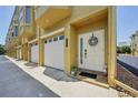 Inviting townhome front entrance with garage, wreath and neutral color scheme at 1061 Pinellas Bayway S, Tierra Verde, FL 33715