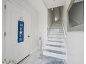 Bright entryway with staircase and decorative beach sign at 1061 Pinellas Bayway S, Tierra Verde, FL 33715