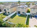 Aerial view of a fenced backyard with healthy green grass and solar panels adorning the roof at 4502 Banyan Tree Pl, Riverview, FL 33578