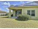 Well-maintained backyard, showcasing a covered patio, green lawn, and energy-efficient solar panels at 1718 Trailwater St, Ruskin, FL 33570
