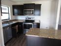 Modern kitchen features stainless steel appliances, dark cabinets, granite countertops and a breakfast bar at 1740 Chatham Green Cir, Ruskin, FL 33570