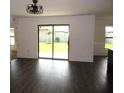 Bright living room with dark wood-look flooring and sliding glass doors leading to the backyard at 1740 Chatham Green Cir, Ruskin, FL 33570