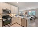 Bright kitchen featuring stainless steel appliances, white cabinets, and marble countertops at 17109 Kenton Ter, Bradenton, FL 34202