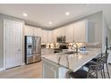 Modern kitchen with white cabinets, stainless steel appliances, and a quartz breakfast bar at 17109 Kenton Ter, Bradenton, FL 34202