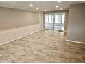 Spacious living room featuring tiled floors, neutral wall colors, crown molding, and sliding glass doors at 12215 Cobble Stone Dr, Hudson, FL 34667