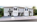 Charming exterior of townhomes featuring individual garages and well-kept landscaping at 5108 Captain Davis Dr, Wimauma, FL 33598