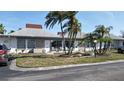 Charming single-story home with a well-maintained lawn, palm trees, and a cozy patio area for outdoor enjoyment at 4329 Tahitian Gardens Cir # B, Holiday, FL 34691