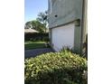 Attached garage with white door and landscaping at 4009 Foxtail Palm Ct # 2, Tampa, FL 33624