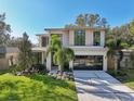 Modern two-story house with a landscaped lawn and attached garage at 1630 Douglas Ave, Dunedin, FL 34698