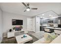 Open living room and kitchen with gray cabinets at 8901 Blind Pass Rd # 228, St Pete Beach, FL 33706