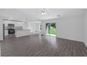 Spacious living room with grey laminate wood flooring and access to backyard at 12169 Patterson Ave, Port Charlotte, FL 33981