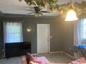 Living room with a pink sofa, ceiling fan, and neutral-toned walls at 36940 Howard Ave, Dade City, FL 33525