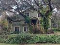 House with green exterior, surrounded by lush trees and foliage at 4623 John Moore Rd, Brandon, FL 33511