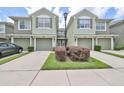 View of a two story townhome with garage, green shutters, landscaping and a double wide driveway at 2220 Kings Palace Dr, Riverview, FL 33578