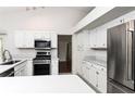 Bright kitchen with stainless steel appliances, white cabinets, and light countertops at 4787 Hamlets Grove Dr, Sarasota, FL 34235