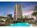 Luxury high-rise building with a resort-style pool and waterfall at dusk at 449 S 12Th St # 2405, Tampa, FL 33602