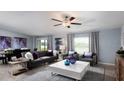 Spacious living room with gray sofa, white coffee table, and large windows at 22075 Blazing Star Run, Land O Lakes, FL 34637