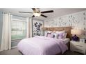 Bright bedroom with a double bed, dog-themed wallpaper, and nightstand at 22075 Blazing Star Run, Land O Lakes, FL 34637