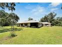Single-story home with metal roof, mature landscaping and large yard at 3003 N Wilder Rd, Plant City, FL 33563