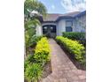 Brick walkway lined with lush green shrubs leading to the front entrance at 12831 Oriago St, Venice, FL 34293