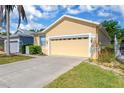 Single-story home featuring an attached two-car garage, well-kept lawn, and welcoming curb appeal at 8049 Sanguinelli Rd, Land O Lakes, FL 34637