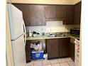 Small kitchen with wood cabinets, microwave, and appliances at 302 E Whitehall Ct # 111, Tampa, FL 33604