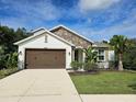 Two-story house with brown garage door and stone accents at 16320 Hyde Manor Dr, Tampa, FL 33647