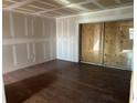 Unfinished bedroom with wood floors and sliding doors at 9027 Westchester Cir # 118, Tampa, FL 33604