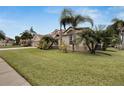House with three car garage, palm trees, and well-maintained lawn at 10301 Manta Way, Tampa, FL 33615
