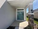 Inviting entrance with stylish front door and stone-accented column at 7002 162Nd E Pl, Parrish, FL 34219