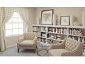 Charming library with built-in bookshelves and two armchairs at 6538 Back Forty Loop, Zephyrhills, FL 33541