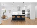 Open-concept kitchen features stainless steel appliances, an island with barstool seating, and hardwood floors at 4005 W San Rafael St, Tampa, FL 33629