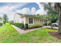 Side view of villa with lush landscaping and walkway at 34903 Double Eagle Ct, Zephyrhills, FL 33541