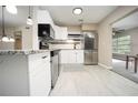 Modern kitchen with white cabinets, granite counters, and stainless steel appliances at 2431 Franciscan Dr # 49, Clearwater, FL 33763