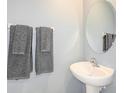 Small bathroom with pedestal sink and gray towels at 2530 Leonia Ln, Zephyrhills, FL 33541