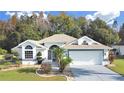 Single-story house with landscaped yard and attached garage at 1707 Tremont Ct, Sun City Center, FL 33573