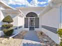 Front entry with screened porch and landscaped walkway at 1707 Tremont Ct, Sun City Center, FL 33573