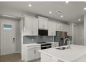 Modern kitchen featuring white cabinets, stainless steel appliances, and a large island at 11223 Livewell Ct, Venice, FL 34293