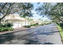 Luxury townhouses with attached garages, lush landscaping, and a quiet tree-lined street at 1708 Triano Cir # 1708, Venice, FL 34292