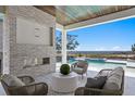 Inviting outdoor living area with a fireplace and water view at 5032 W Longfellow Ave, Tampa, FL 33629
