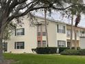 Two-story condo building with green lawn and trees at 201 Silver Lake Dr # 101, Venice, FL 34292