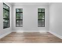 Spacious bedroom featuring hardwood floors, neutral walls, and large windows at 3109 W Knights Ave, Tampa, FL 33611