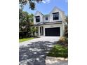 Beautiful two story home with a black garage door and brick driveway at 3109 W Knights Ave, Tampa, FL 33611