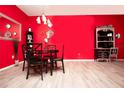 Red walls, a round glass dining table with black chairs at 12811 Kings Crossing Dr, Gibsonton, FL 33534