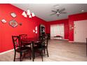 Red walls, a round glass dining table with black chairs at 12811 Kings Crossing Dr, Gibsonton, FL 33534