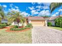 Home's exterior showcasing a large driveway and palm trees at 2156 Mesic Hammock Way, Venice, FL 34292