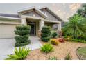 Single-Gathering house with two-car garage, lush landscaping, and stone accents at 903 Heritage Groves Dr, Brandon, FL 33510