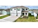 Stunning two-story home featuring a manicured lawn, a three-car garage and gorgeous water view at 11946 Brighton Knoll Loop, Riverview, FL 33579